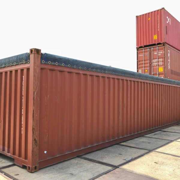 Shipping container covered by a black tarp